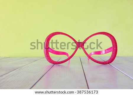 festival  retro pink eyeglasses on wooden table