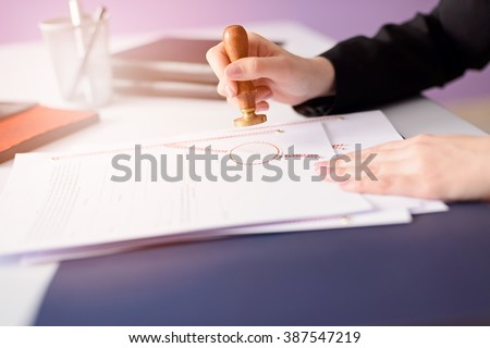 Notary Public stamping the document. Law office concept.  Royalty-Free Stock Photo #387547219