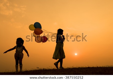 childrens play balloon silhouette at sunset