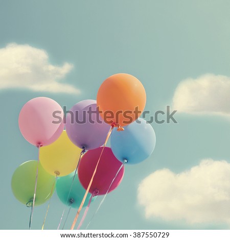 Bunch of colorful balloons on a blue sky with vintage editing