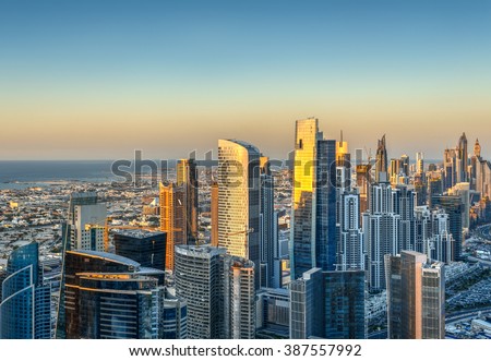 Beautiful skyline with modern architecture at sunset. Aerial view of Dubai business bay towers. Royalty-Free Stock Photo #387557992