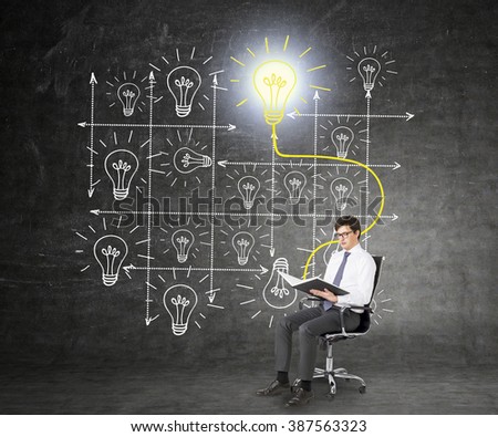 A businessman sitting on a castor chair and reading a book,  system of bulbs drawn behind him, the book and the shining yellow bulb linked. Black background. Concept of studying