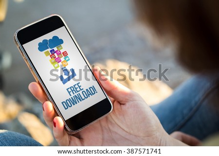 close-up view of young woman downloading with her mobile phone. All screen graphics are made up.
