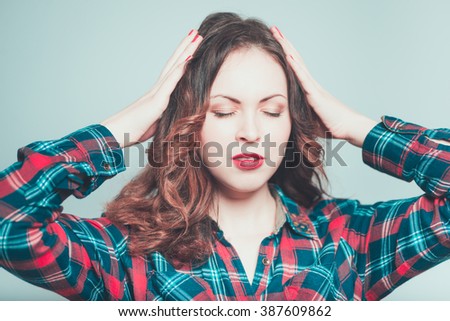 Portrait of a young woman has a headache isolated on a gray background