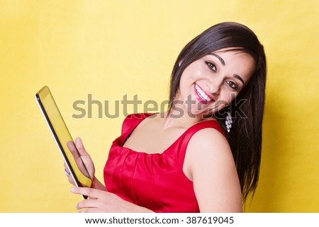 Smiling woman in red dress holds tablet