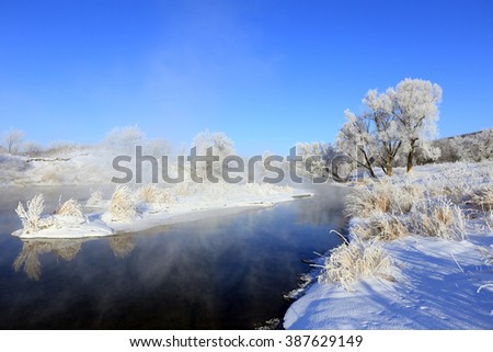 foggy winter landscape frosty morning over the river and trees in hoarfrost on the shores of