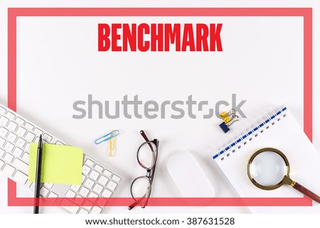 High angle view of various office supplies on desk with a word BENCHMARK