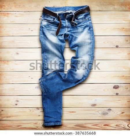 Blue jeans trouser with leather belt over white wood planks background