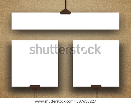 Close-up of three hanged square and rectangular paper sheet frames with clips on brown canvas background