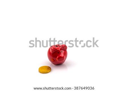 Close up of red piggy bank isolated on white background with golden coin