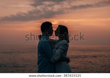 Honeymoon on the ocean. Photo shoot. Couple silhouette at sunset