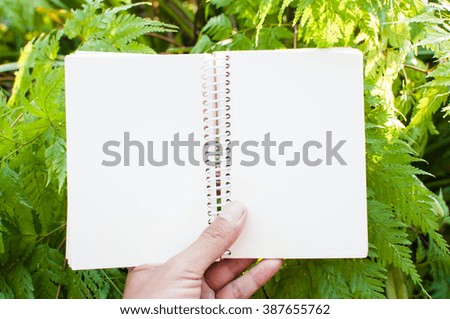 notebook with blurry nature background.
