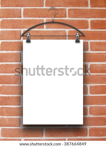 Close-up of one hanged paper sheet frame with clothes hanger on brick wall background