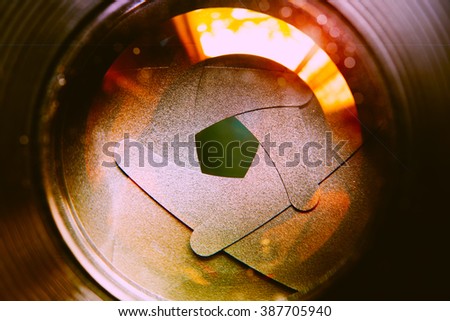 The diaphragm of lens aperture with flare. Selective focus with shallow depth of field. Vintage filtered image tone. Conceptual of concentration.