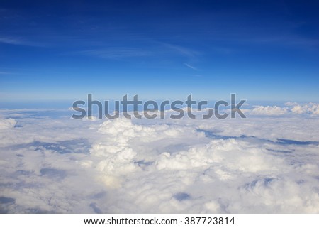 Photo of puffy clouds and blue sky from above the clouds