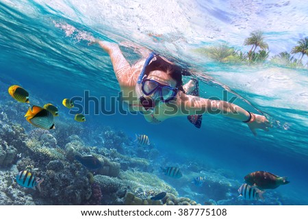 Beautiful women snorkeling in the tropical sea Royalty-Free Stock Photo #387775108