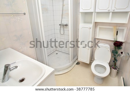 interior of small white bathroom with sink shower and toilet Royalty-Free Stock Photo #38777785