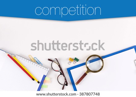 High angle view of various office supplies on desk with a word Competition