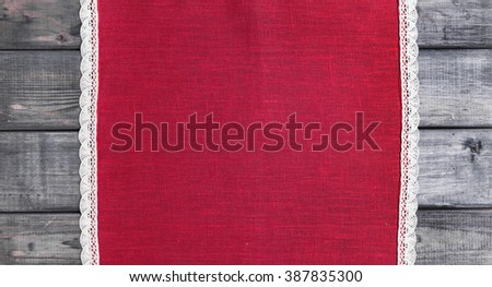 On a gray background of wooden red cloth with white linen woven handmade lace
