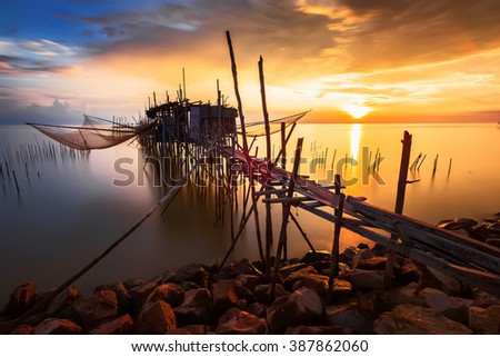 Long exposure image of "langgai" during sunset , the traditional fishing medium at Malaysia. Soft focus, noise and grain due long exposure. Royalty-Free Stock Photo #387862060