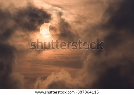 Partial sun eclipse (around 41 percent) behind dark cloude in Bangkok, Thailand on 9 March 2016.
