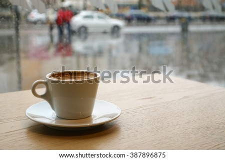 Cup of coffee on a rainy day window background