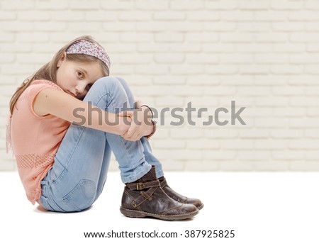 a pre-teen girl sad n is sitting on the floor
