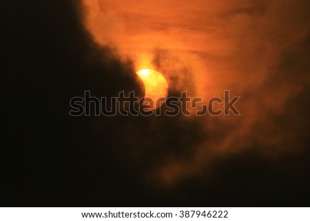 Partial solar eclipse through clouds in bangkok,Thailand