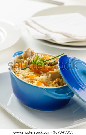 A small cooking pot with rice, vegetables and rabbit meat.