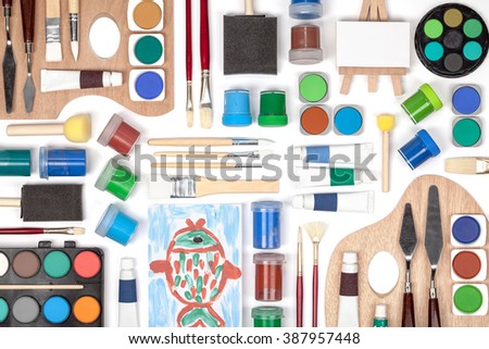 painting equipment: brushes, palette and paints on white background. flat lay composition in green, blue and brown colors top view