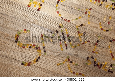 "smile" written with gummy bears on a wooden table