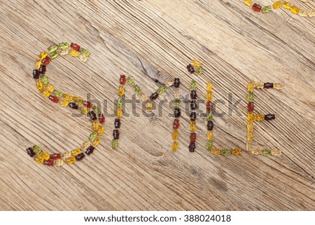 Smile written with gummy bears on a wooden table