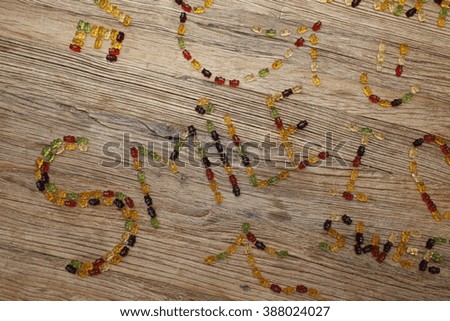 "Smile" written with gummy bears on a wooden table
