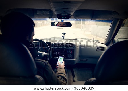 Dangerous driving while writing SMS text message Royalty-Free Stock Photo #388040089