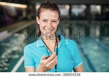 Trainer woman holding a stopwatch on poolside
