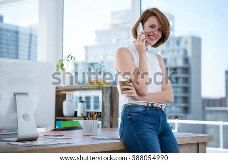 smiling hipster business woman, holding a coffee and makin a phone calleg