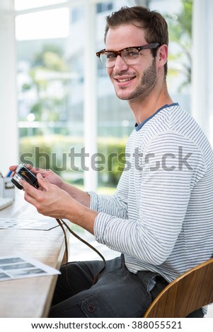 Handsome man looking at pictures on camera in a bright office