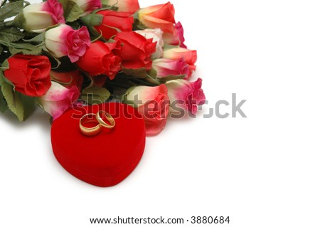 Flowers, heart-shaped box and wedding rings isolated on white