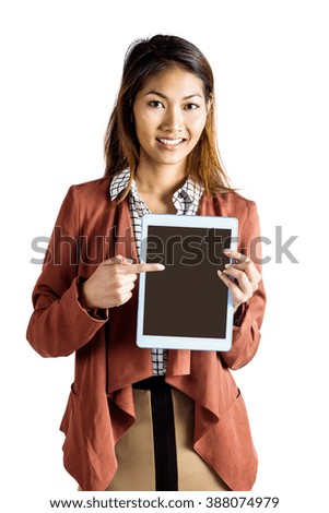 Smiling businesswoman pointing a tablet on white background