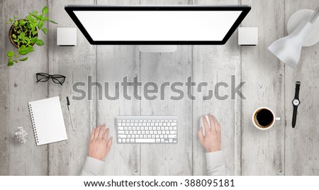 Modern desk with isolated computer display top view. Designer works with a mouse and keyboard. Coffee, lamp, paper, glasses, plant, watch on table.