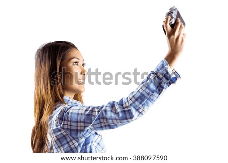 Smiling asian woman taking picture with camera on white background