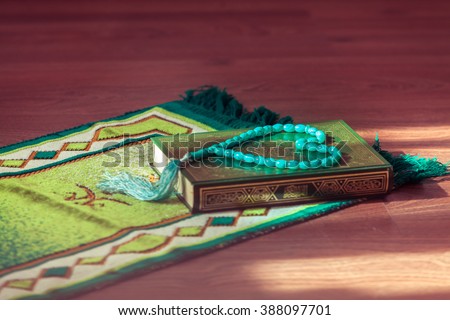 Mat for prayer , the rosary and the holy book the Koran. Royalty-Free Stock Photo #388097701