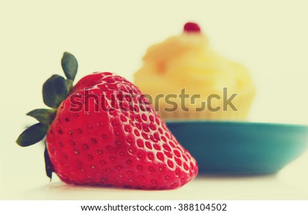 fresh strawberry and cupcake on a blue tray. Vintage style picture