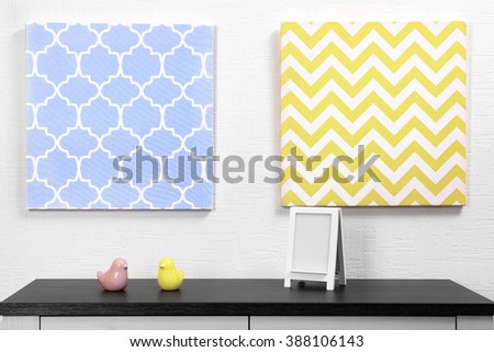 Photo frame and decorations on table with pictures in light room
