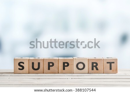 Support sign with blocks on a wooden office desk