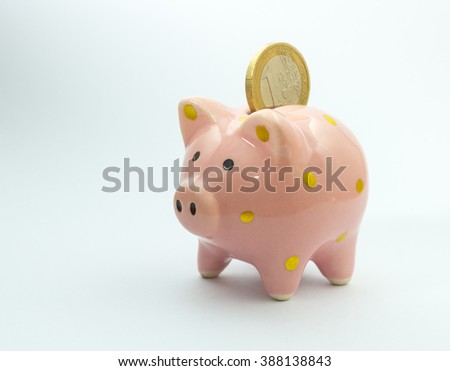 1 euro coin falling in piggy bank, isolated on white background