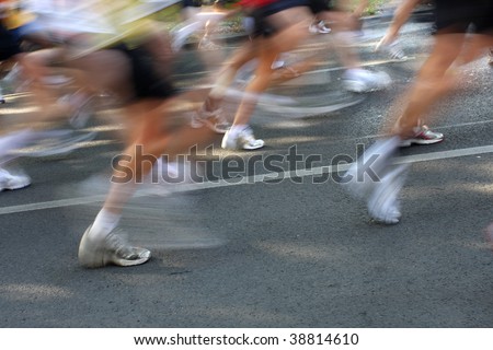 picture of many people running a marathon with motion blur and cropped bodies.