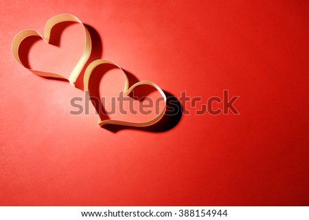 Valentine's Day heart made of ribbon on red background