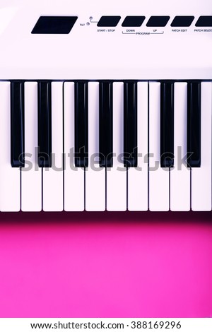 Keyboard of synthesizer on pink background