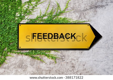 Feedback on yellow sign hanging on ivy wall
